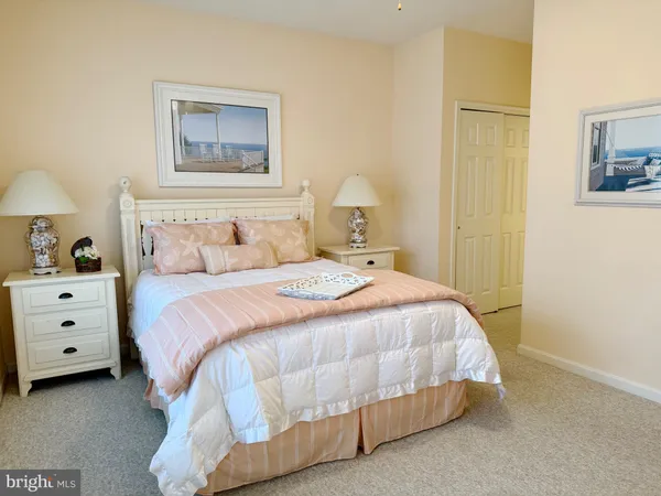 a bedroom with a bed and a lamp on dresser