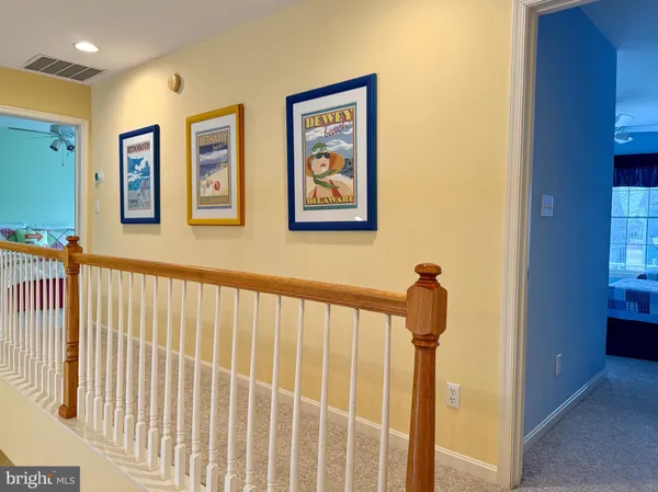 a view of staircase with lots of frames on wall and a large window