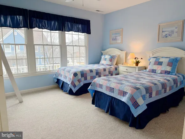 a spacious bedroom with two beds and large window