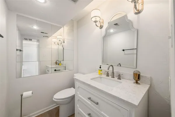 a bathroom with a sink toilet vanity and shower