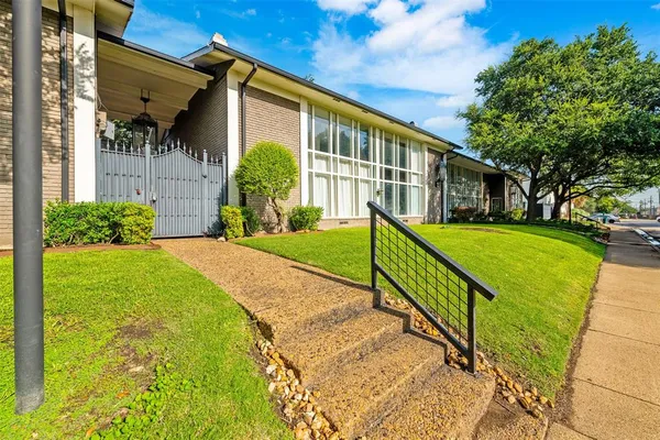 a view of a house with backyard and a tree