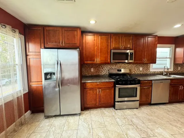 a kitchen with a sink a toilet and cabinets