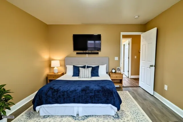 a view of an empty room with wooden floor and closet