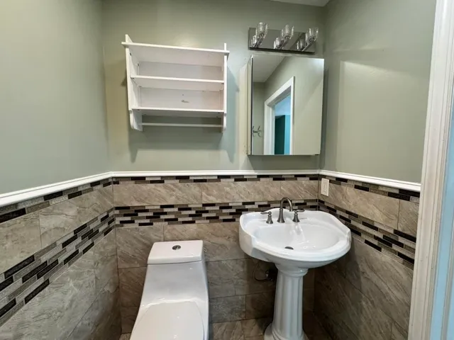 a bathroom with a toilet a sink and mirror