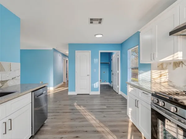 a kitchen with granite countertop a stove and cabinets