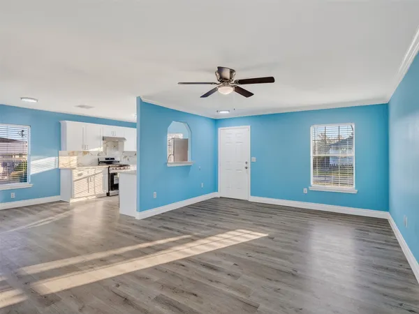 a view of an empty room with window and wooden floor