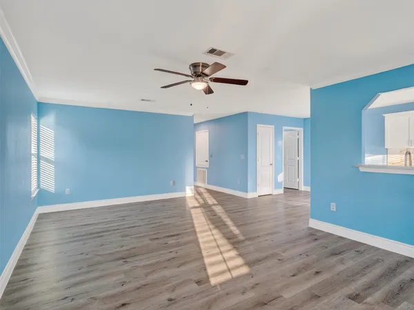 a view of a room with wooden floor and a ceiling fan
