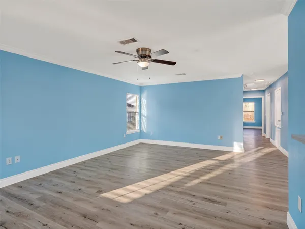 a view of a room with wooden floor and a ceiling fan