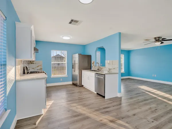 a kitchen with a refrigerator and a stove top oven