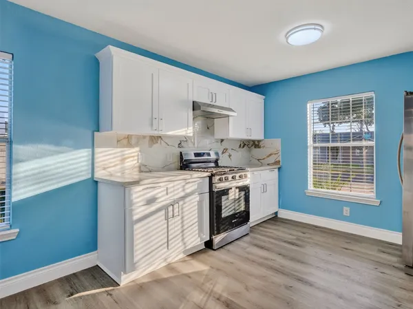 a kitchen with stainless steel appliances granite countertop a stove a sink and a microwave