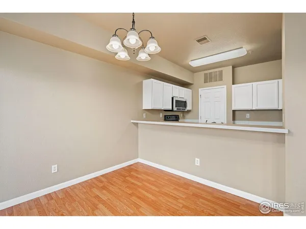 a kitchen with cabinets and wooden floor