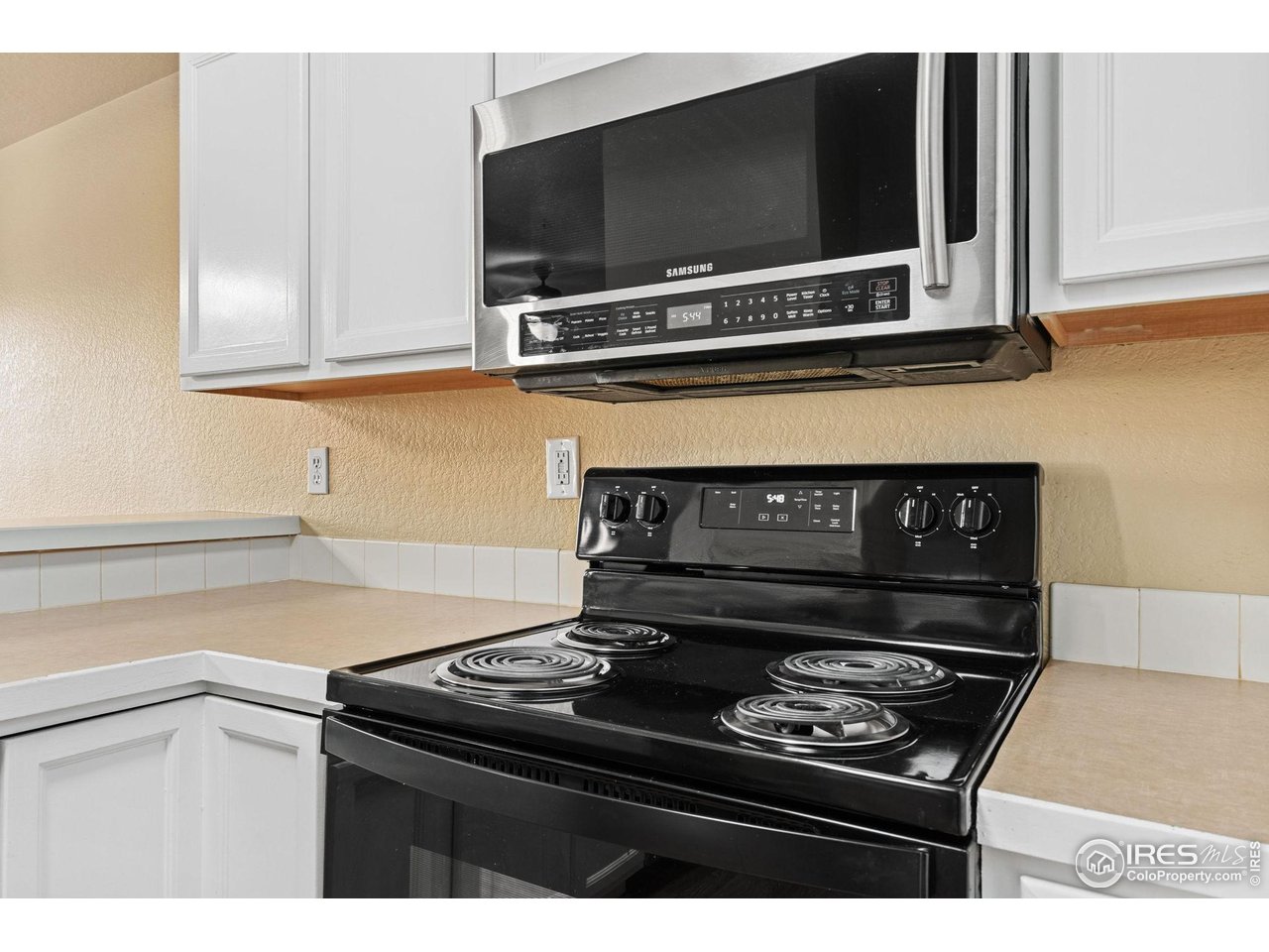 6925 19th Street, Unit 15 Greeley, CO 80634 - Photo 16 of 32 a kitchen with a stove and a microwave