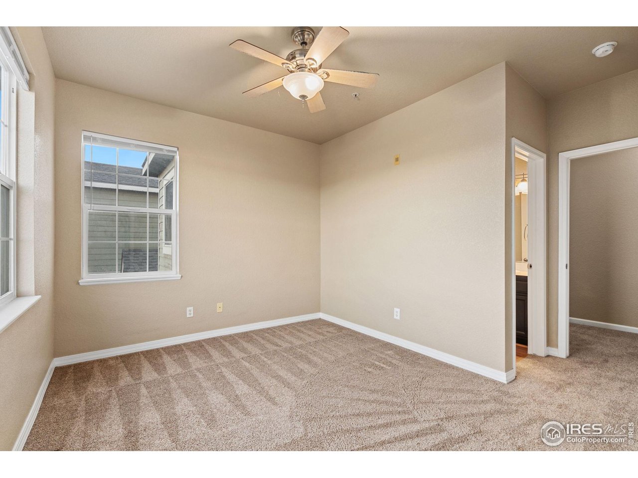 6925 19th Street, Unit 15 Greeley, CO 80634 - Photo 21 of 32 a view of an empty room with a window and a ceiling fan