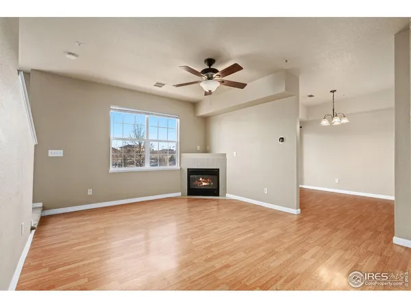 a view of an empty room with a window and fireplace