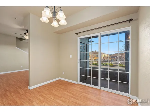 a view of empty room with a window and wooden floor