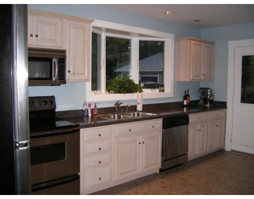 9 Hillside Road Newton, MA 02461 - Photo 4 of 9 a kitchen with granite countertop white cabinets and black stainless steel appliances