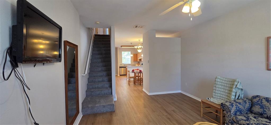 3970 Southwest 20th Avenue, Unit 912 Gainesville, FL 32607 - Photo 3 of 29 a view of a hallway with wooden floor and a living room
