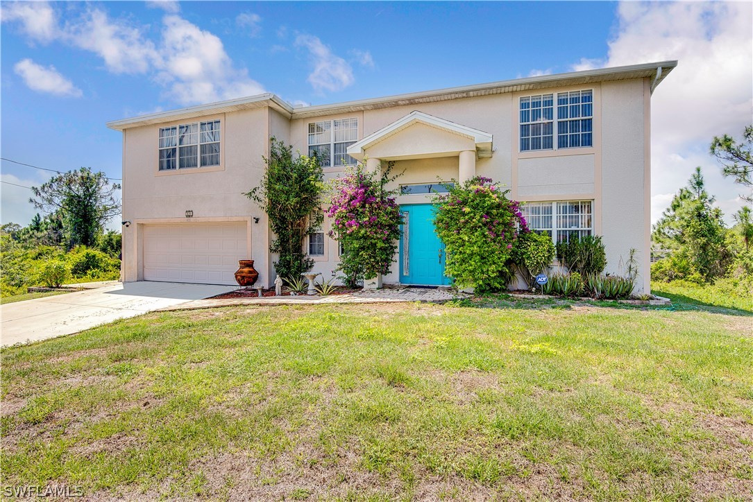 421 Jourferie Road Lehigh Acres, FL 33974 - Photo 1 of 25 a front view of house with yard and trees in the background