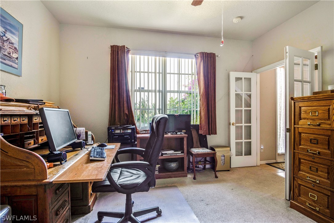 421 Jourferie Road Lehigh Acres, FL 33974 - Photo 12 of 25 a view of a workspace with furniture and a window