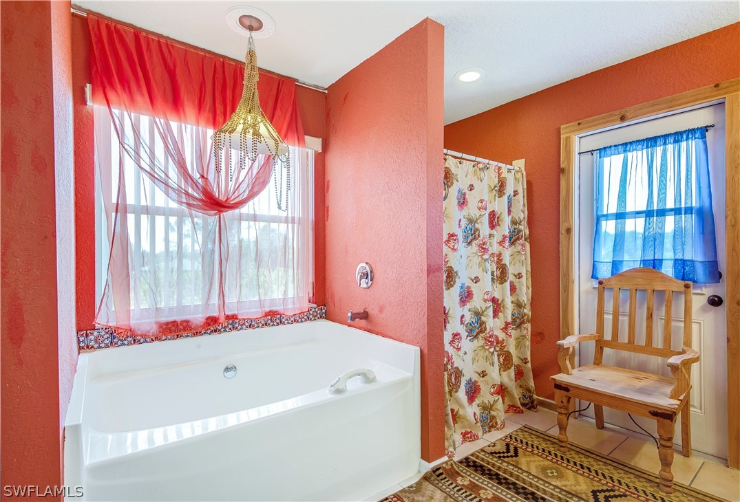 421 Jourferie Road Lehigh Acres, FL 33974 - Photo 15 of 25 a bathroom with a bathtub and a shower