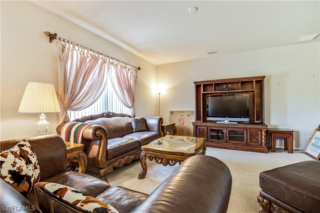 421 Jourferie Road Lehigh Acres, FL 33974 - Photo 5 of 25 a living room with furniture and a flat screen tv