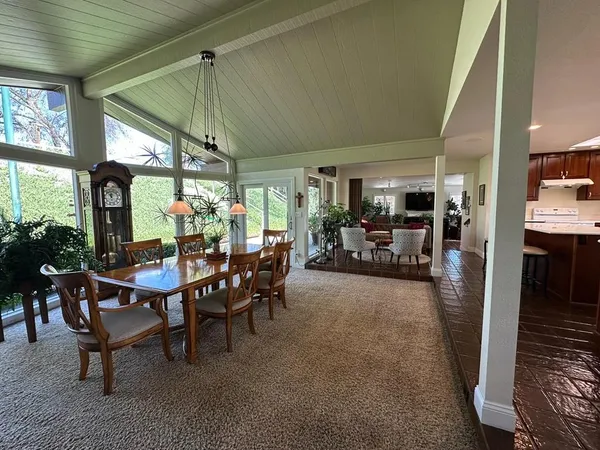 a living room with furniture a flat screen tv and a dining table