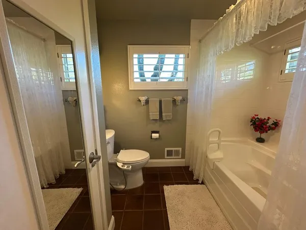 a view of a lake with a floor to ceiling window and wooden fence
