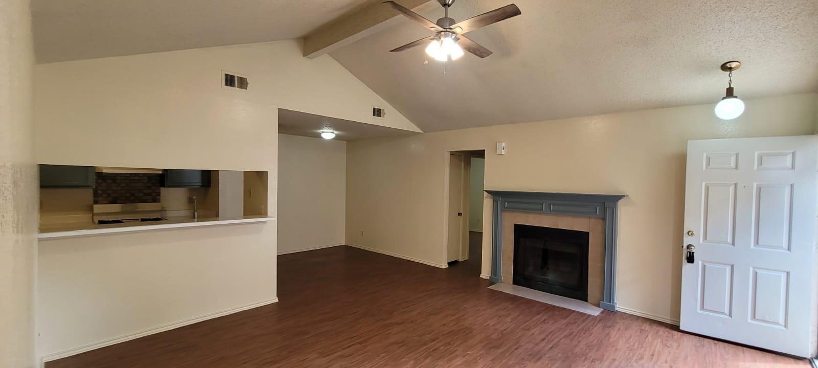 a view of a livingroom with wooden floor and a fireplace