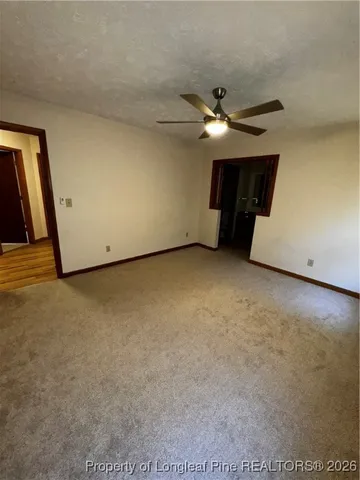 an empty room with a ceiling fan and window