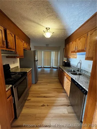 a large kitchen with granite countertop lots of counter top space and stainless steel appliances