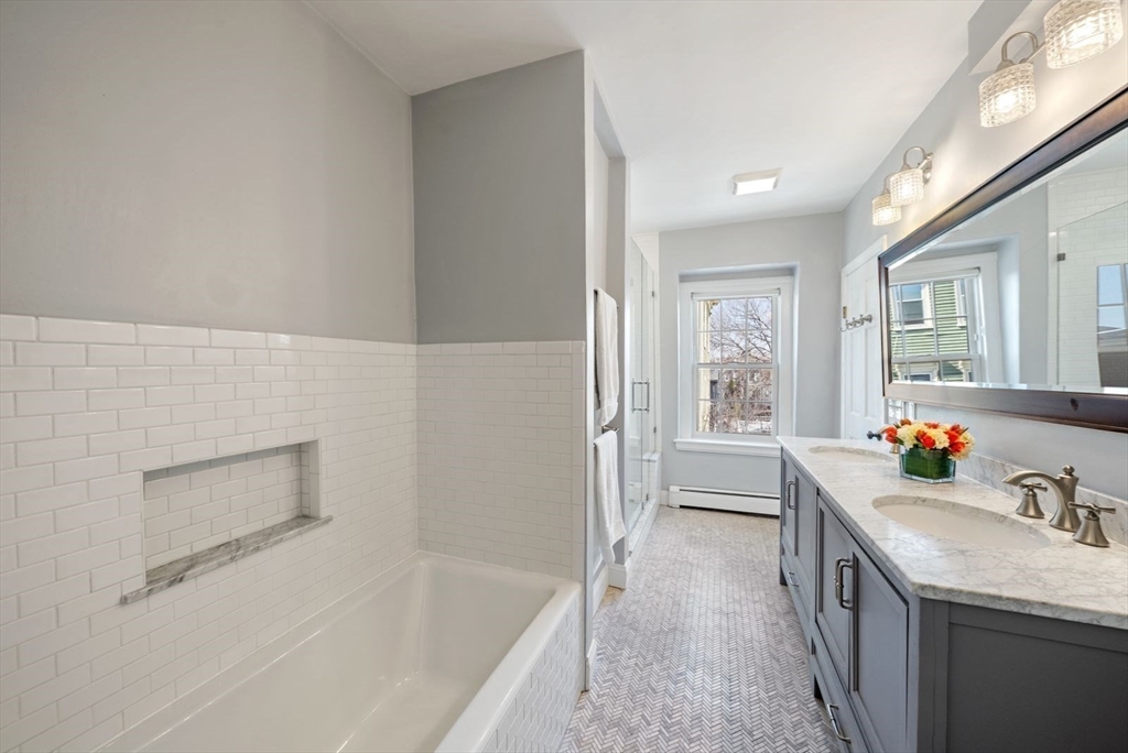 10 Summer Street, Unit 1 Boston, MA 02129 - Photo 25 of 37 a bathroom with a tub sink and mirror