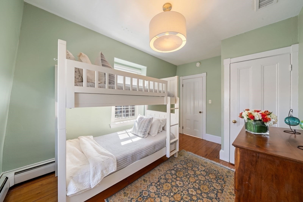 10 Summer Street, Unit 1 Boston, MA 02129 - Photo 27 of 37 a bedroom with a bed and a chandelier
