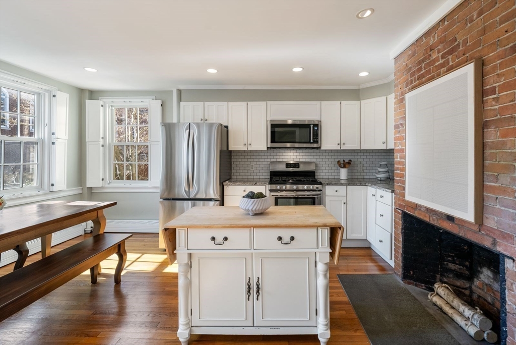 10 Summer Street, Unit 1 Boston, MA 02129 - Photo 10 of 37 a kitchen with stainless steel appliances granite countertop a stove top oven a sink a refrigerator and white cabinets