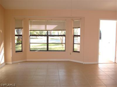18270 Lee Road Fort Myers, FL 33967 - Photo 4 of 4 an empty room with wooden floor and windows