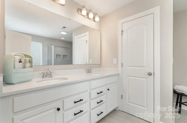 a bathroom with double vanity sink a vanity and mirrors