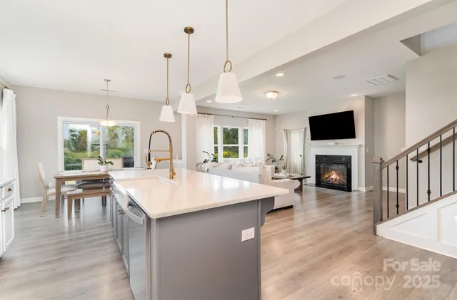 a room with fireplace a center island a sink a stove and a wooden floor