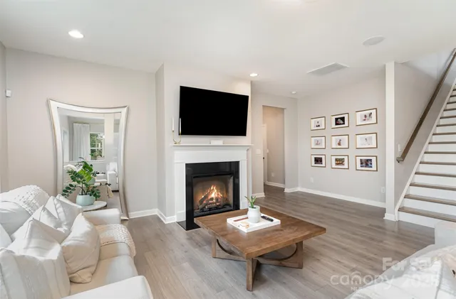 a living room with furniture a fireplace and a flat screen tv