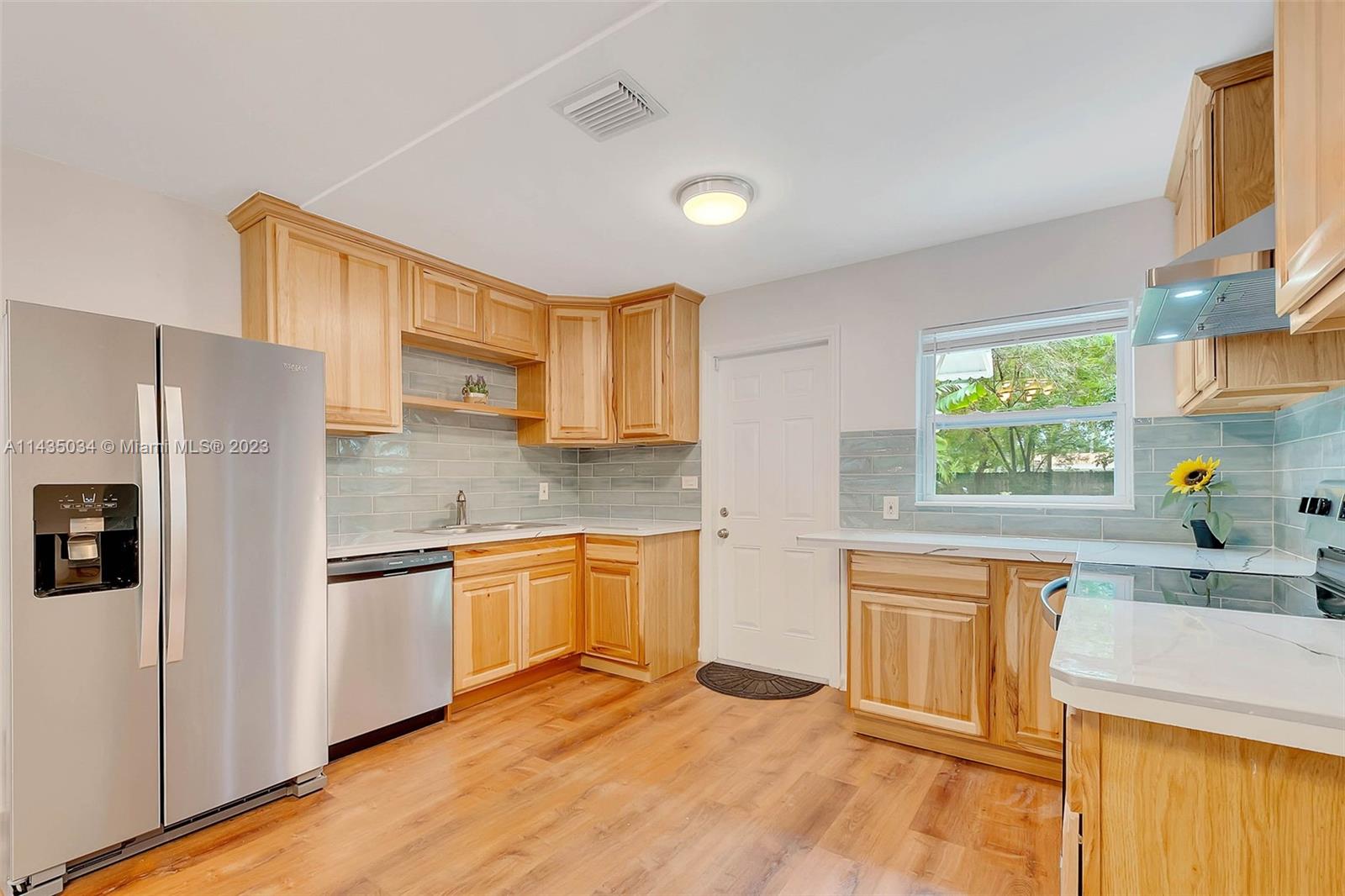 1023 Northwest 3rd Avenue Homestead, FL 33030 - Photo 11 of 32 a kitchen with stainless steel appliances granite countertop a refrigerator sink and cabinets