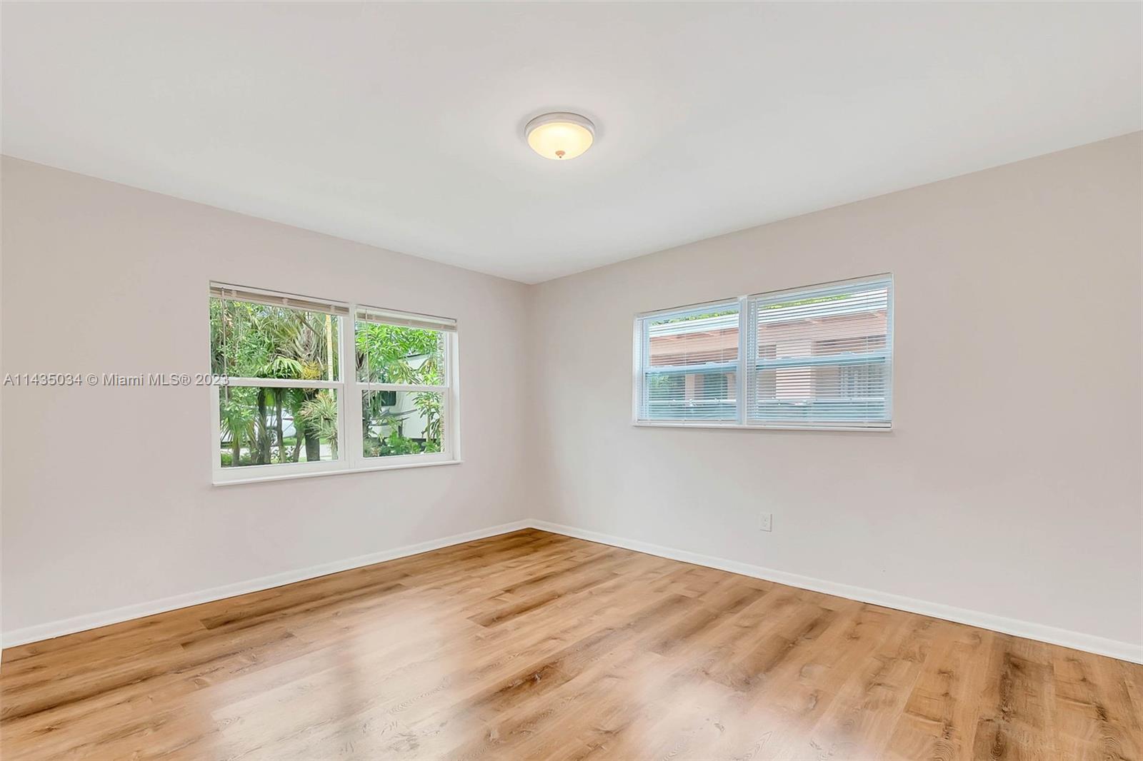 1023 Northwest 3rd Avenue Homestead, FL 33030 - Photo 14 of 32 a view of an empty room with wooden floor and a window
