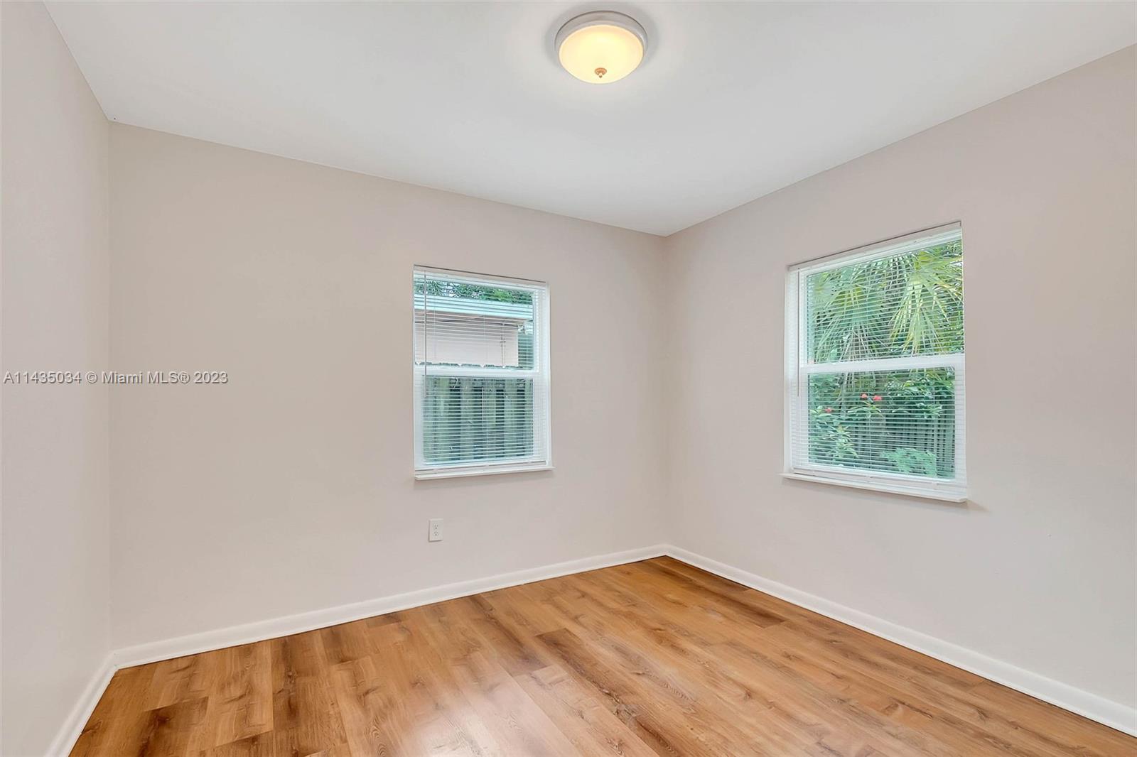 1023 Northwest 3rd Avenue Homestead, FL 33030 - Photo 16 of 32 a view of an empty room with wooden floor and a window