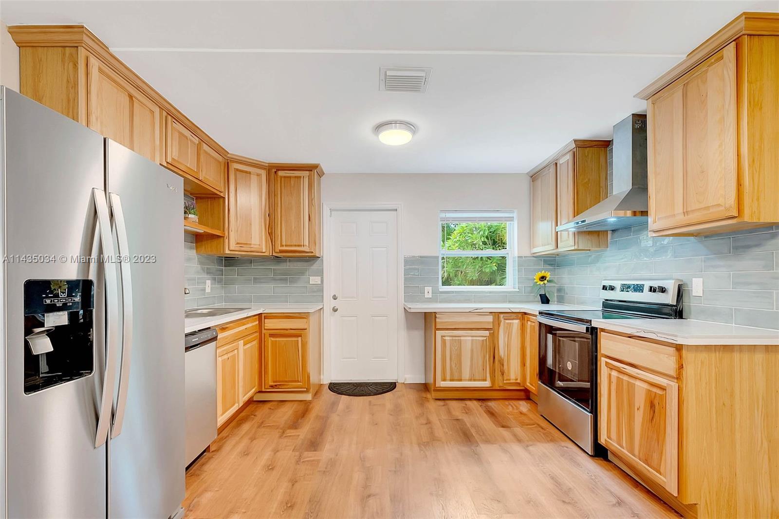 1023 Northwest 3rd Avenue Homestead, FL 33030 - Photo 3 of 32 a kitchen with stainless steel appliances granite countertop a stove a sink dishwasher a refrigerator and cabinets with wooden floor