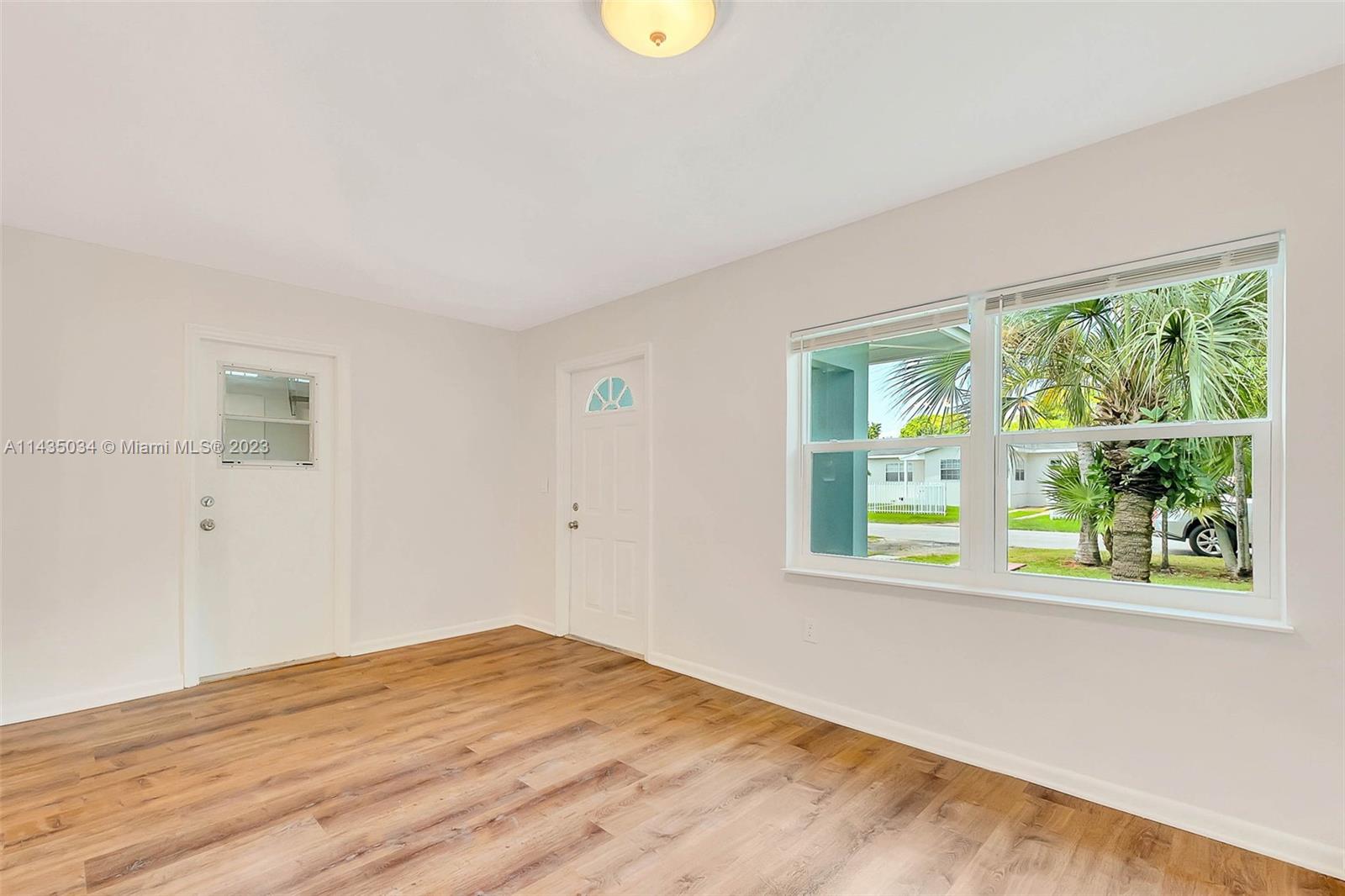 1023 Northwest 3rd Avenue Homestead, FL 33030 - Photo 9 of 32 a view of an empty room with wooden floor and a window