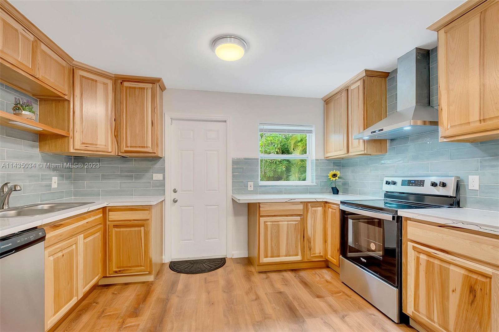 1023 Northwest 3rd Avenue Homestead, FL 33030 - Photo 10 of 32 a kitchen with stainless steel appliances granite countertop a sink and cabinets