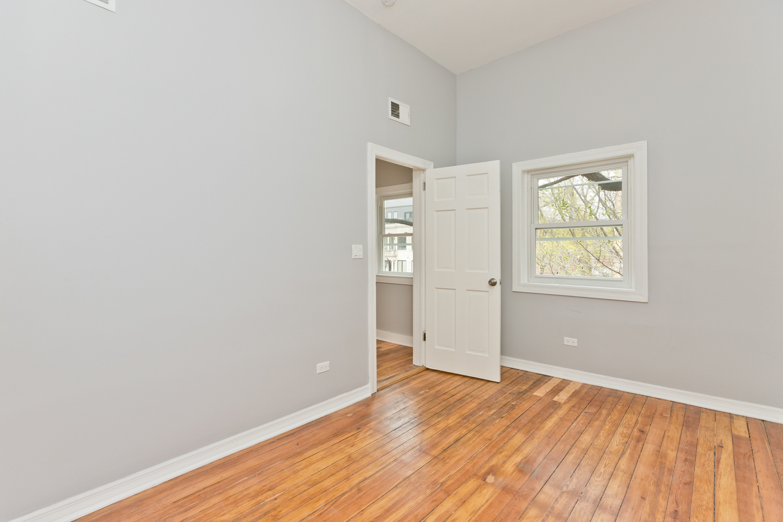 1300 West Addison Street, Unit 1 Chicago, IL 60613 - Photo 11 of 14 an empty room with wooden floor and windows