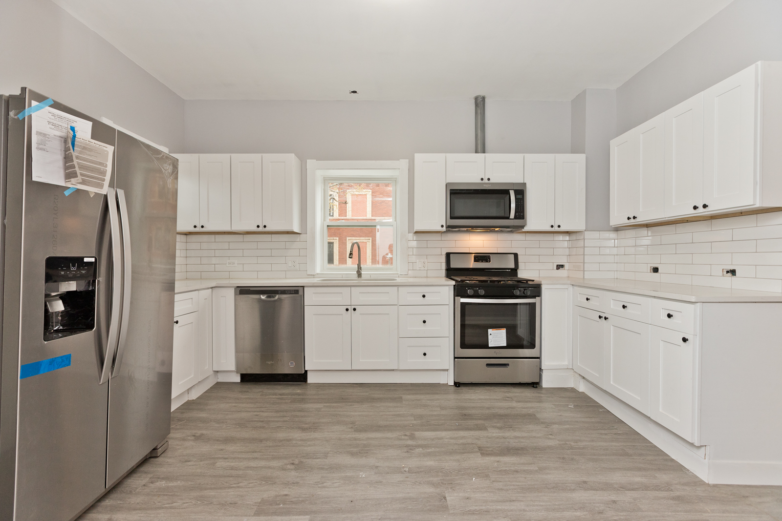 1300 West Addison Street, Unit 1 Chicago, IL 60613 - Photo 2 of 14 a kitchen with white cabinets and stainless steel appliances
