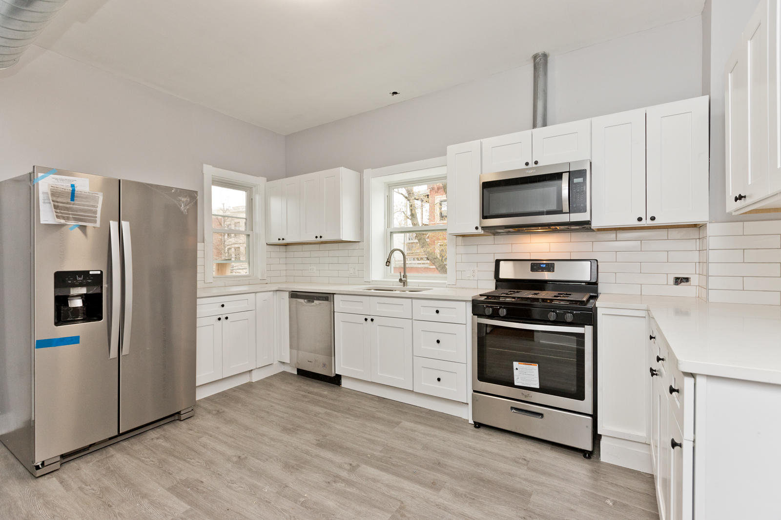 1300 West Addison Street, Unit 1 Chicago, IL 60613 - Photo 3 of 14 a kitchen with stainless steel appliances a stove a sink dishwasher a refrigerator and a microwave