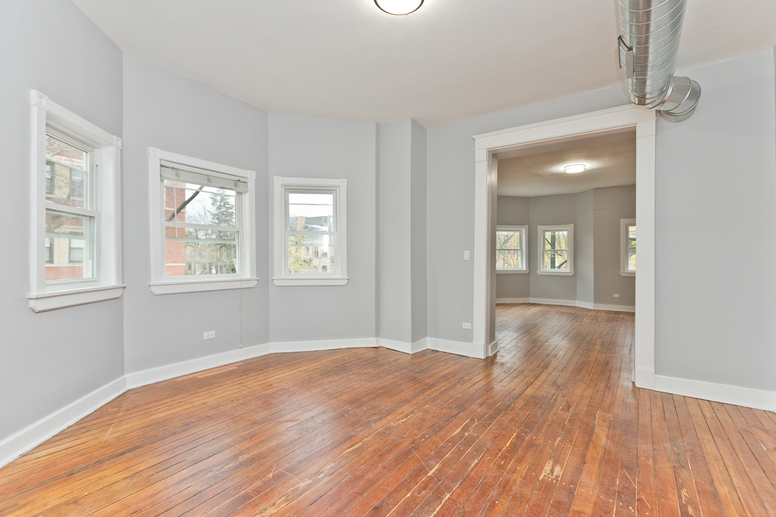 1300 West Addison Street, Unit 1 Chicago, IL 60613 - Photo 4 of 14 a view of an empty room with wooden floor and a window