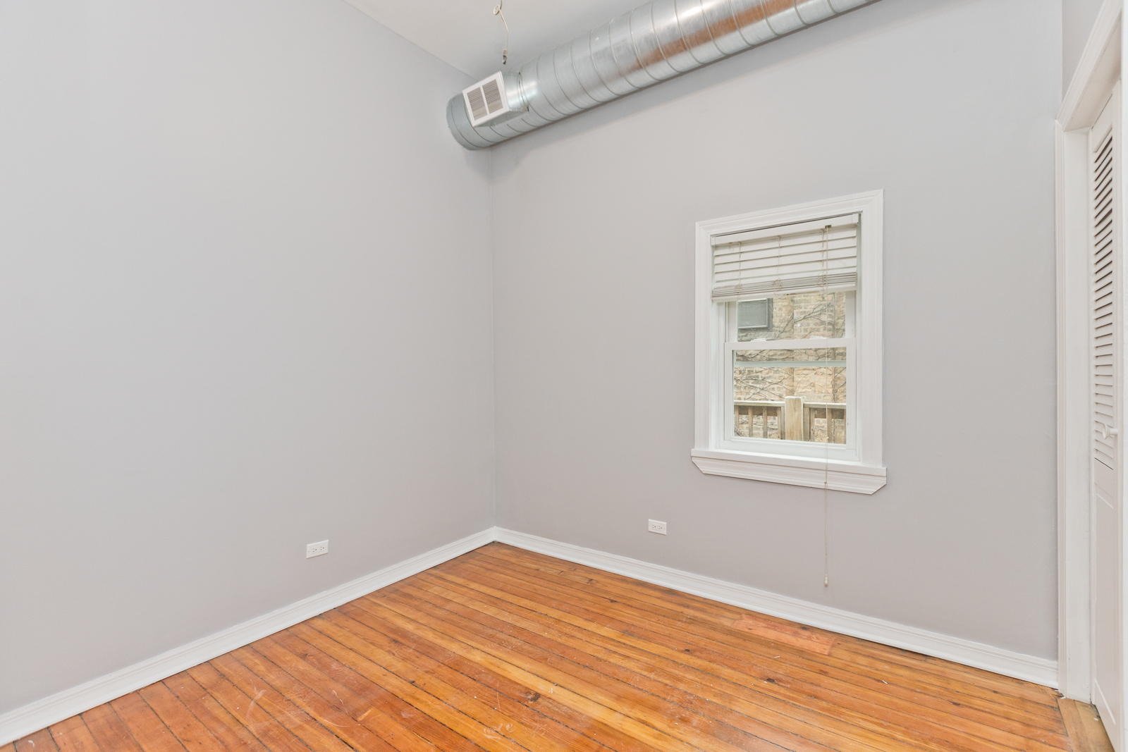 1300 West Addison Street, Unit 1 Chicago, IL 60613 - Photo 6 of 14 an empty room with wooden floor and windows