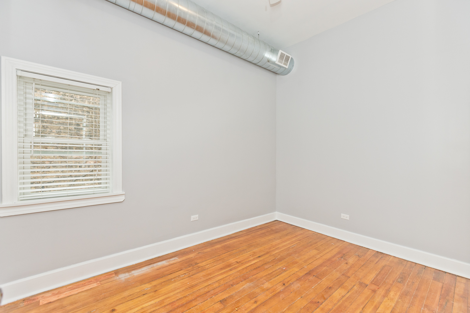 1300 West Addison Street, Unit 1 Chicago, IL 60613 - Photo 8 of 14 a view of an empty room with wooden floor and a window