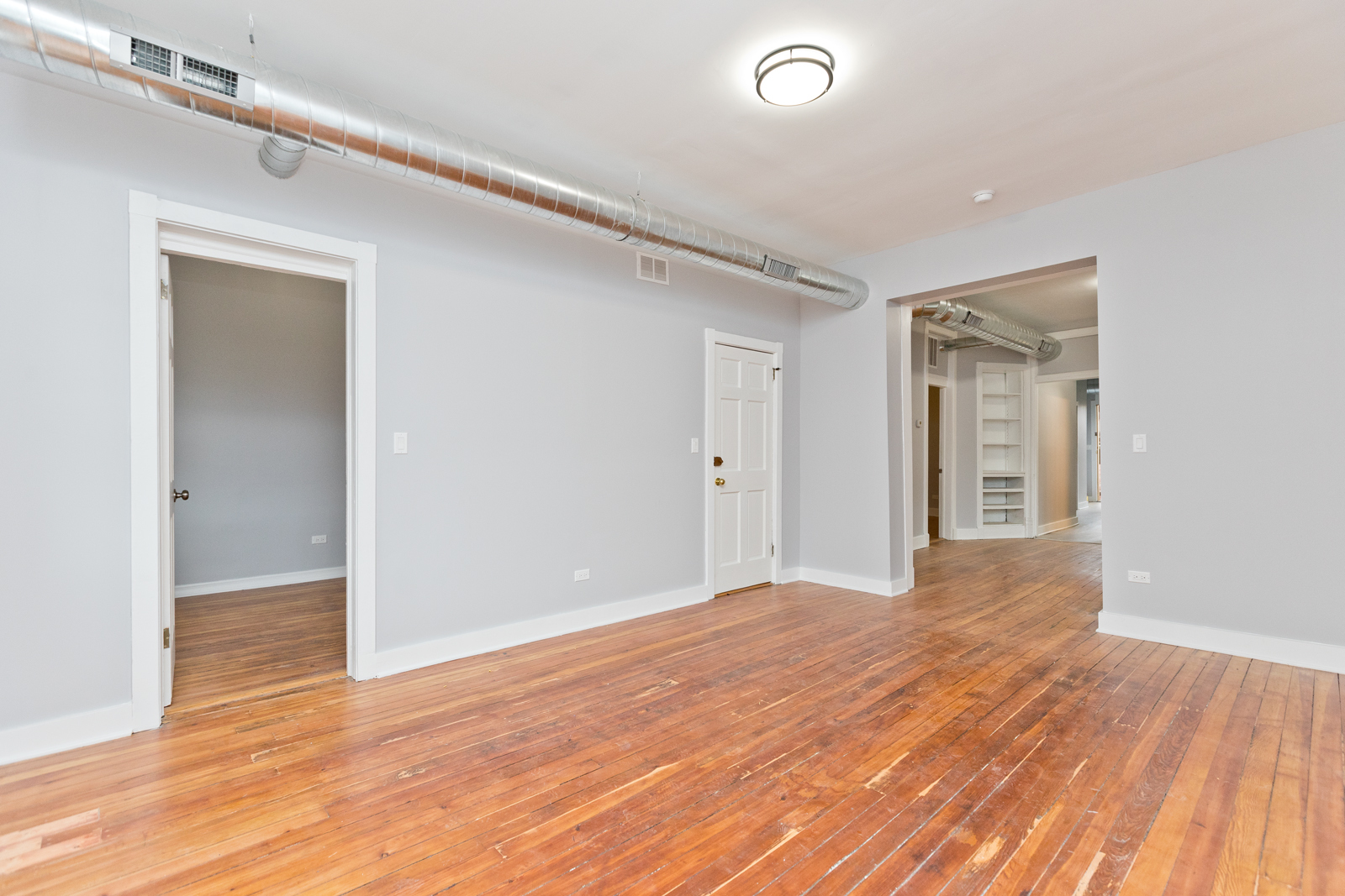 1300 West Addison Street, Unit 1 Chicago, IL 60613 - Photo 9 of 14 a view of an empty room with wooden floor and a window